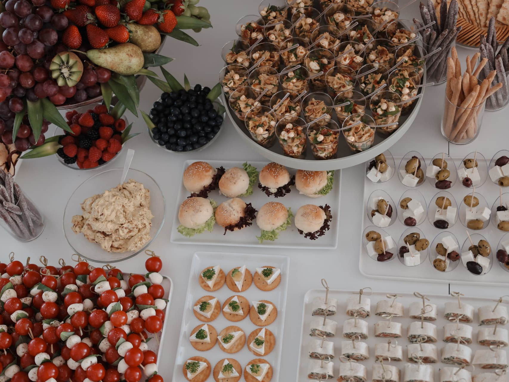 Festlich gedeckte Apéro-Tafel mit Dessert-Etagere, Blumen und Gläsern